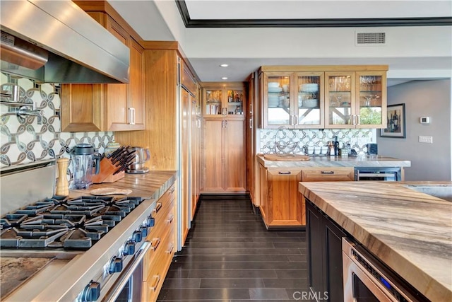 kitchen with dark hardwood / wood-style flooring, backsplash, butcher block countertops, high end range, and exhaust hood