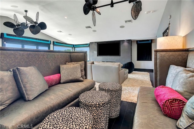 cinema room with wood-type flooring, ceiling fan, and lofted ceiling