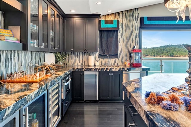 kitchen featuring dark wood-type flooring, tasteful backsplash, vaulted ceiling, and dark stone counters