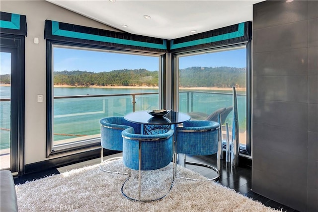 sunroom / solarium featuring a wealth of natural light, a water view, and lofted ceiling