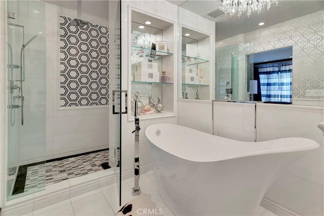 bathroom featuring plus walk in shower, a chandelier, and tile patterned floors