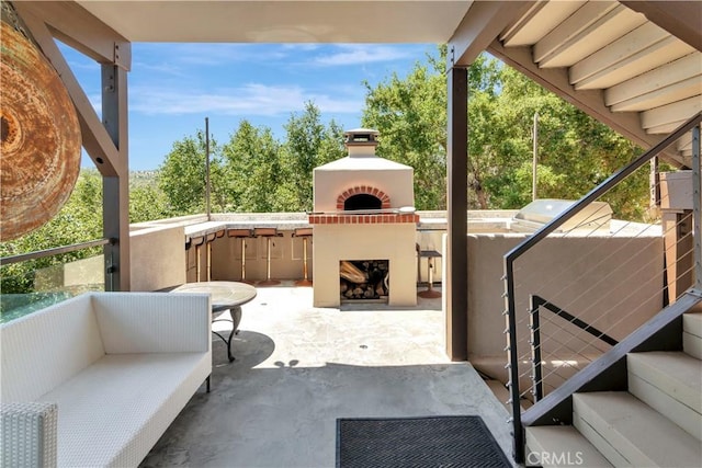 view of patio / terrace featuring an outdoor living space with a fireplace and grilling area