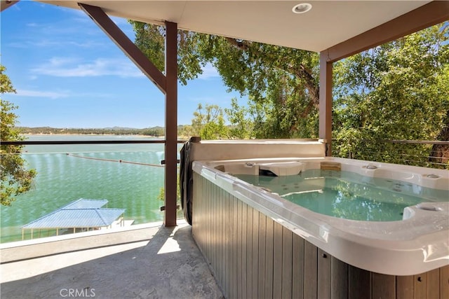 exterior space featuring a water view and a hot tub