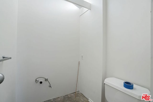 bathroom with concrete flooring and toilet