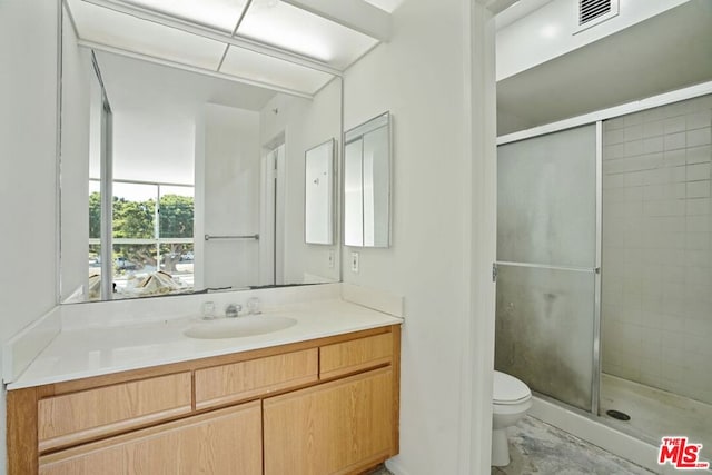 bathroom featuring vanity, toilet, and an enclosed shower