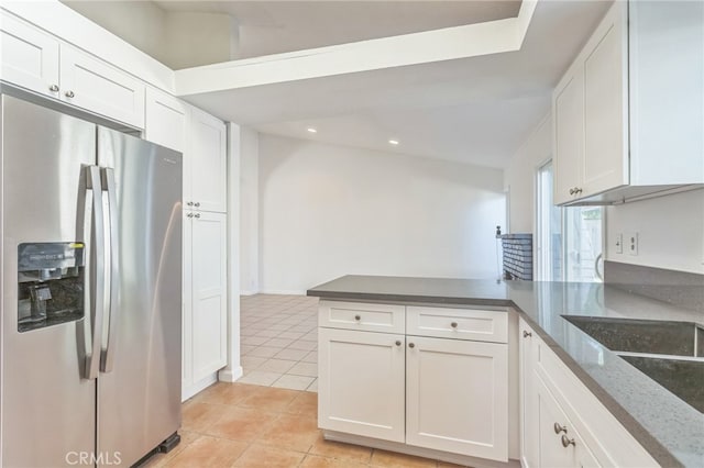 kitchen with white cabinetry, kitchen peninsula, and stainless steel fridge