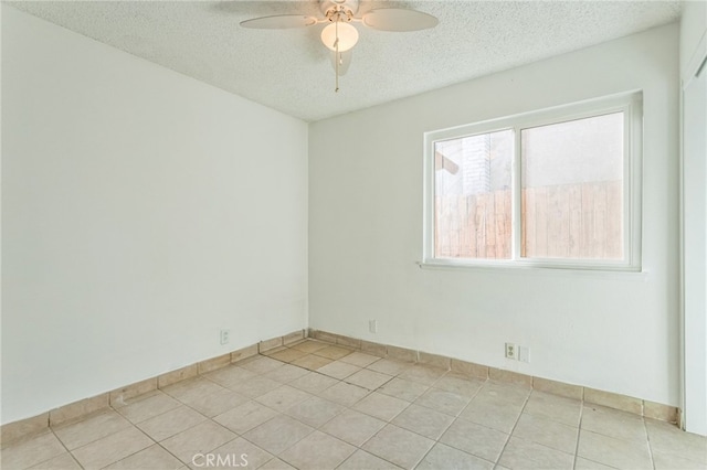 tiled empty room with a textured ceiling and ceiling fan