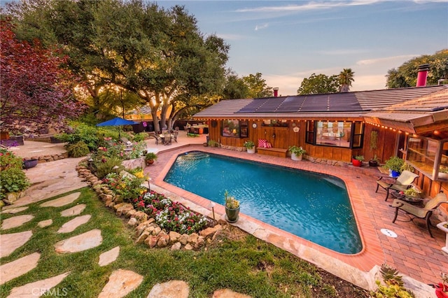 pool at dusk with a patio