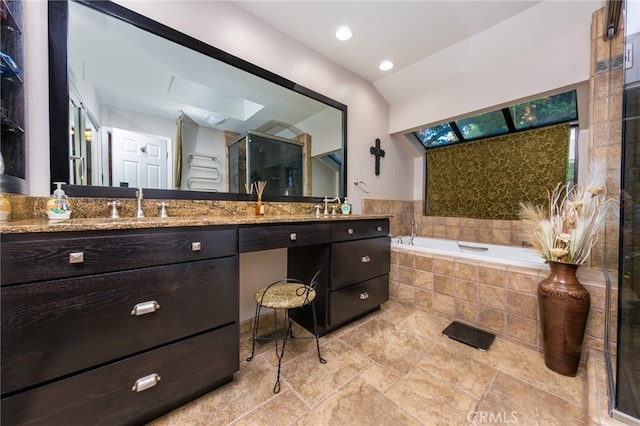 bathroom featuring vanity, separate shower and tub, and a skylight