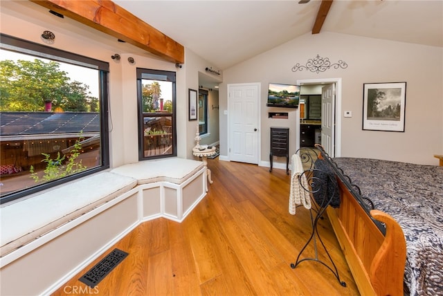 interior space featuring light hardwood / wood-style flooring and vaulted ceiling with beams