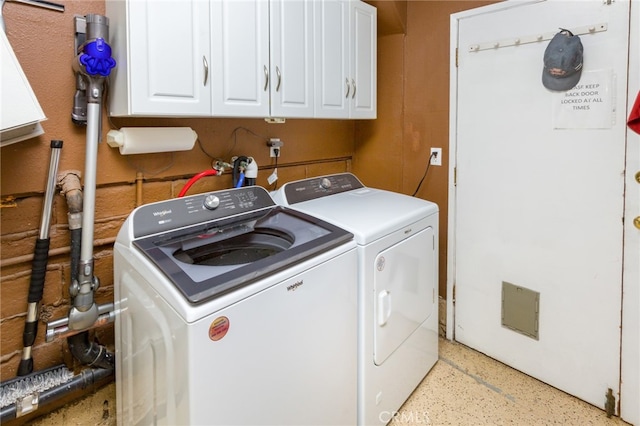 clothes washing area featuring cabinets and separate washer and dryer