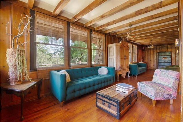 living room featuring beam ceiling, wood-type flooring, and wooden walls