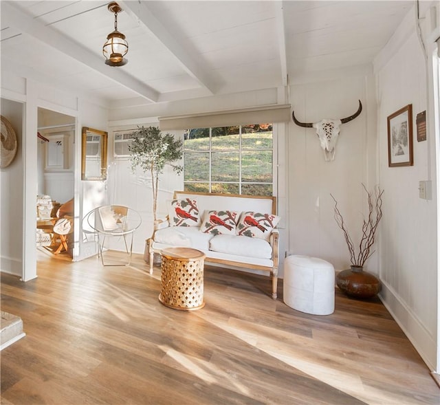 unfurnished room with beam ceiling, a wall mounted air conditioner, and hardwood / wood-style flooring