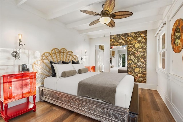 bedroom featuring beam ceiling, dark hardwood / wood-style floors, and ceiling fan