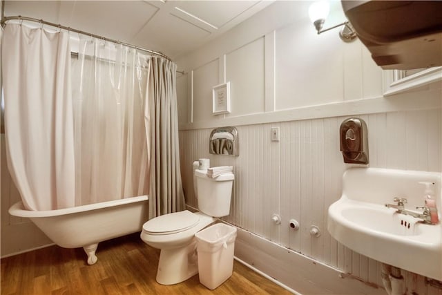 full bathroom featuring toilet, hardwood / wood-style floors, shower / tub combo with curtain, and sink