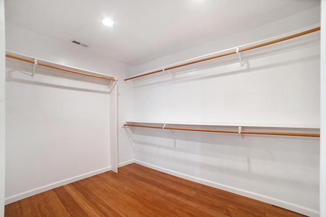 walk in closet with hardwood / wood-style flooring