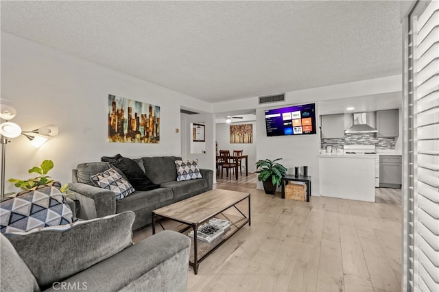 living room featuring light hardwood / wood-style floors and a textured ceiling