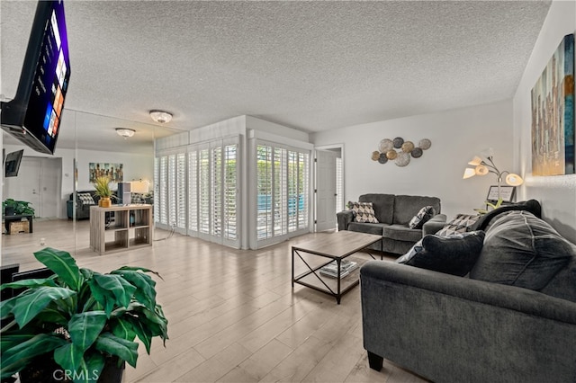 living room with a textured ceiling and light wood-type flooring