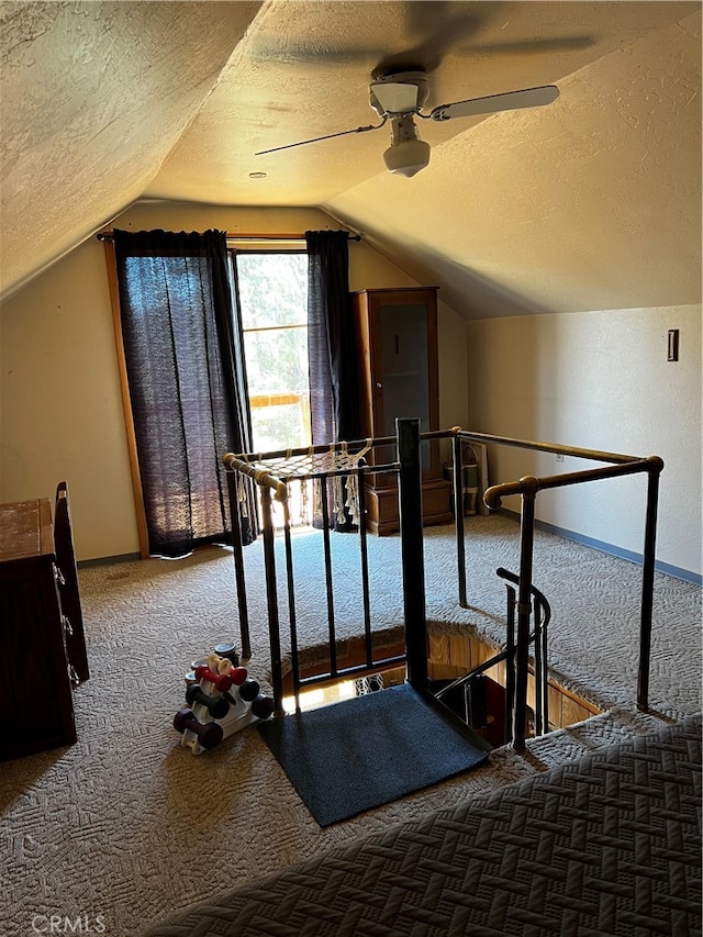 interior space featuring a textured ceiling, lofted ceiling, and ceiling fan