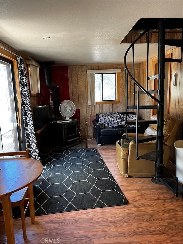 97390 Dome View Ave, Kennedy Meadows, CA 93527 - living area with a wood stove, wood finished floors, wood walls, and a textured ceiling