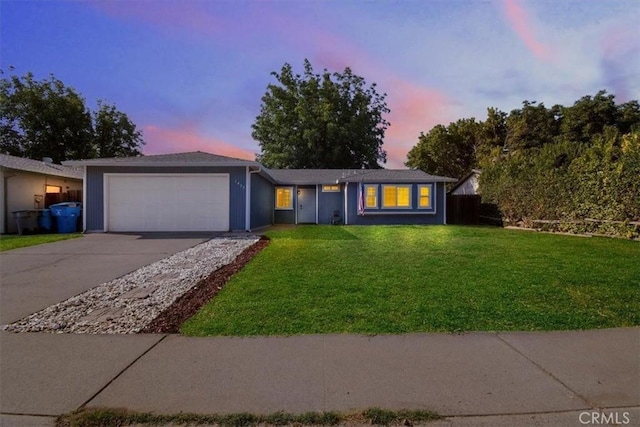 single story home featuring a garage and a lawn