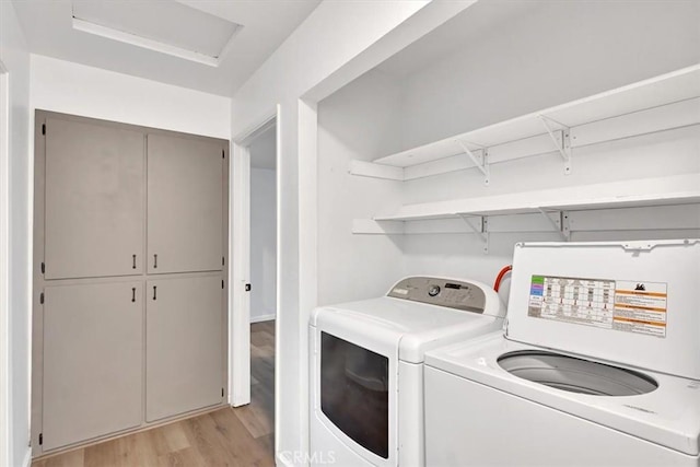 clothes washing area with light hardwood / wood-style floors and independent washer and dryer