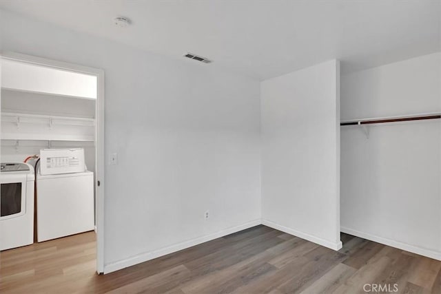 clothes washing area featuring washer and dryer and hardwood / wood-style flooring