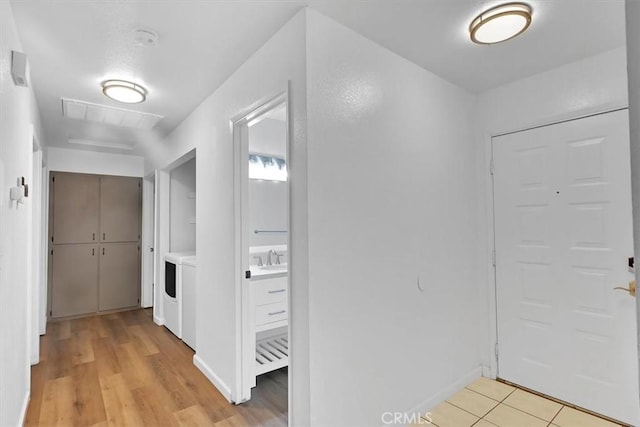 hallway featuring separate washer and dryer and light hardwood / wood-style flooring