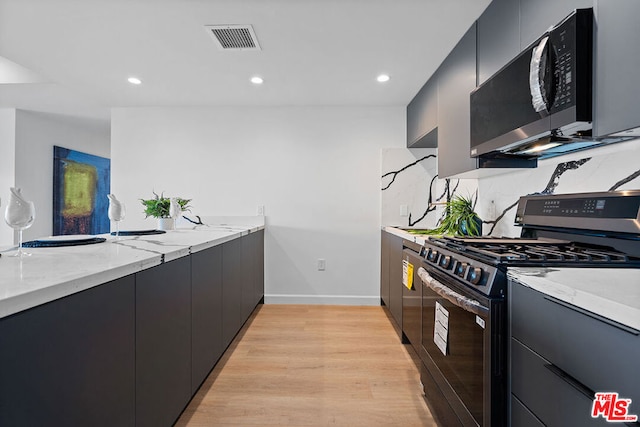 kitchen featuring light hardwood / wood-style flooring, appliances with stainless steel finishes, and light stone countertops