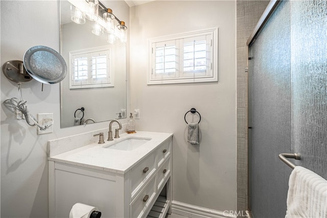 bathroom featuring a shower with door and vanity