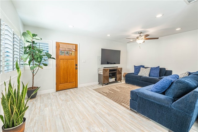 living room featuring light hardwood / wood-style flooring and ceiling fan