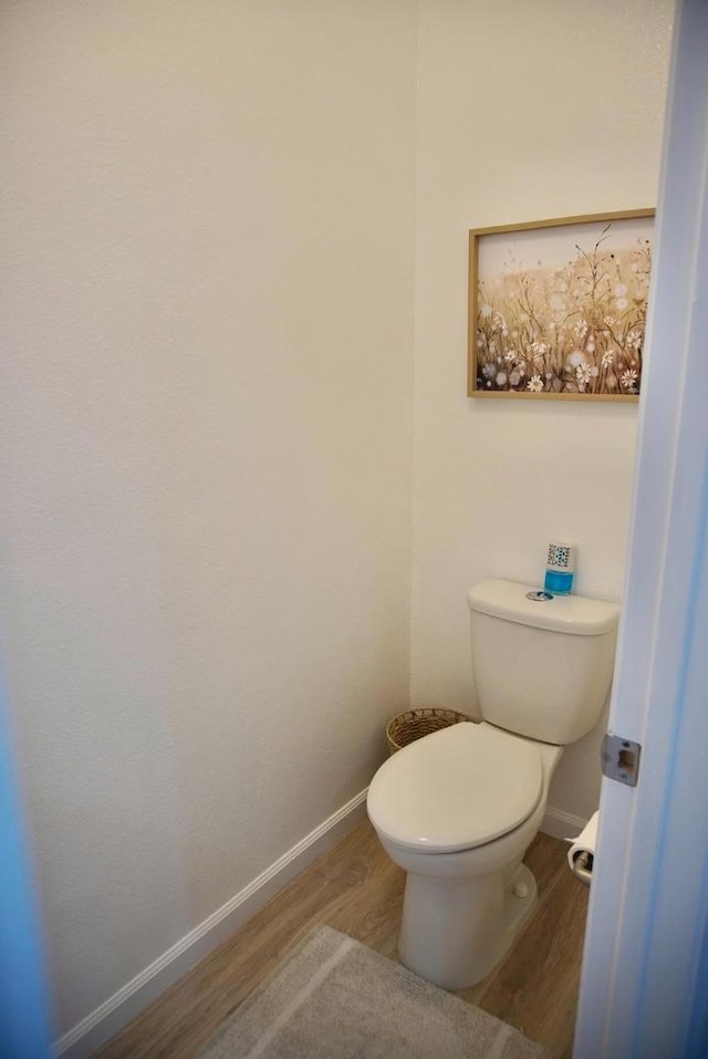 bathroom with hardwood / wood-style floors and toilet