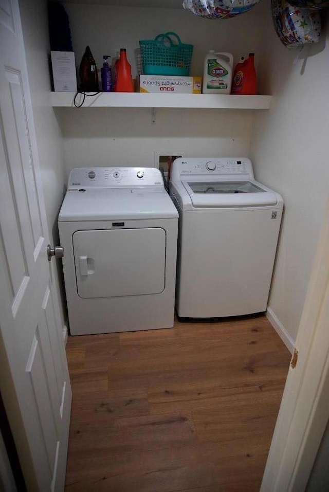 washroom featuring washer and clothes dryer and wood-type flooring