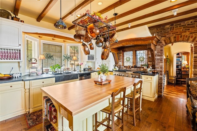 kitchen featuring a healthy amount of sunlight, beamed ceiling, and dark hardwood / wood-style flooring