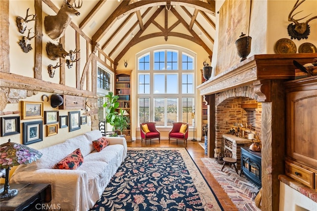 sitting room featuring beam ceiling, a fireplace, a healthy amount of sunlight, and high vaulted ceiling