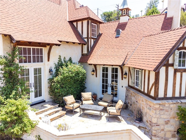 back of property with french doors, an outdoor living space, and a patio area