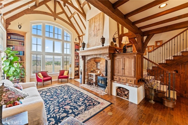 living room with dark wood-type flooring, high vaulted ceiling, a wood stove, and beamed ceiling