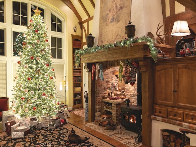 room details featuring beam ceiling, wood-type flooring, and a wood stove