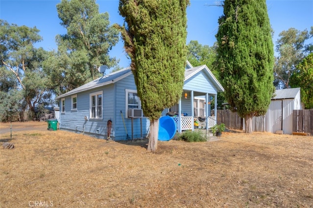 view of front of home featuring cooling unit and a storage unit