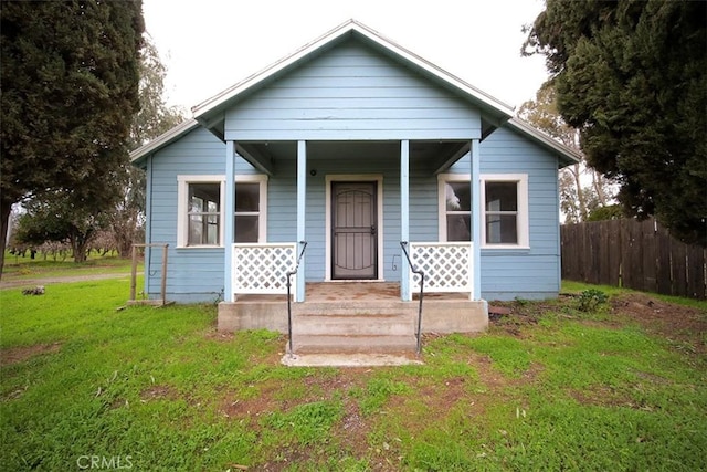 bungalow featuring covered porch and a front lawn