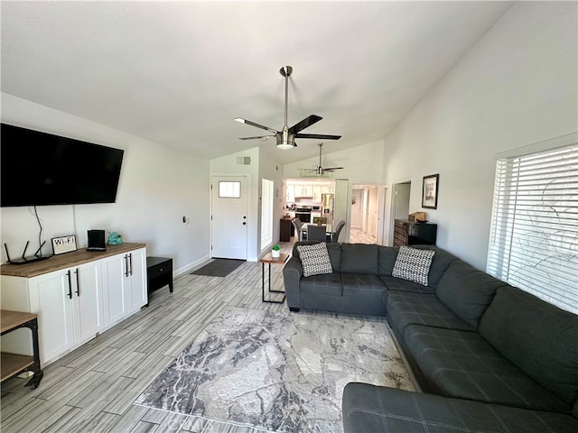 living room featuring light hardwood / wood-style floors, vaulted ceiling, and ceiling fan