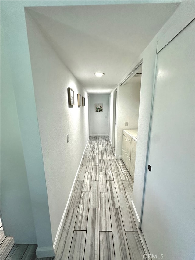 hallway featuring light hardwood / wood-style flooring and washer and dryer