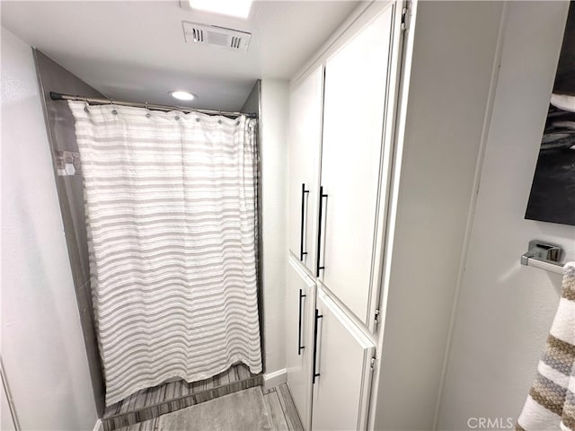 bathroom featuring a shower with shower curtain and hardwood / wood-style flooring