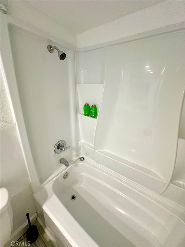 bathroom with shower / washtub combination and toilet