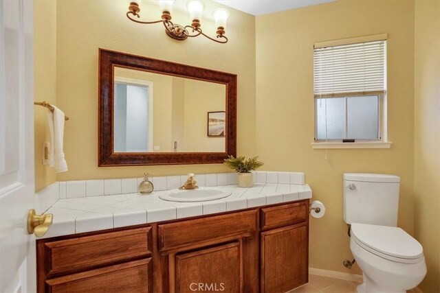 bathroom with tile patterned flooring, vanity, and toilet