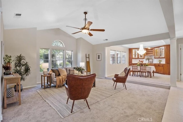 living area featuring a ceiling fan, plenty of natural light, light colored carpet, and visible vents