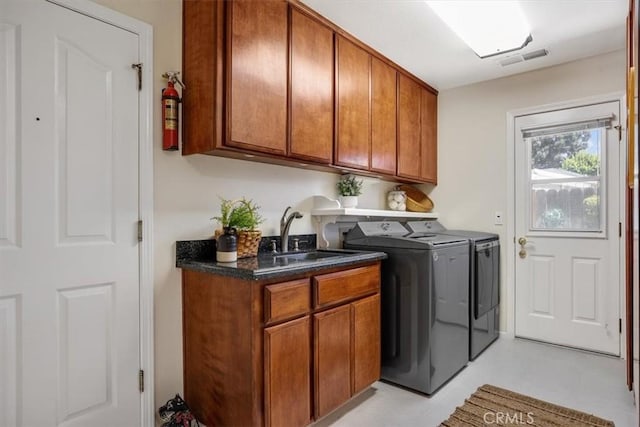 washroom featuring washer and clothes dryer, sink, and cabinets