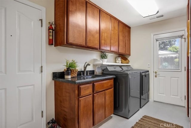 laundry area featuring independent washer and dryer, visible vents, cabinet space, and a sink