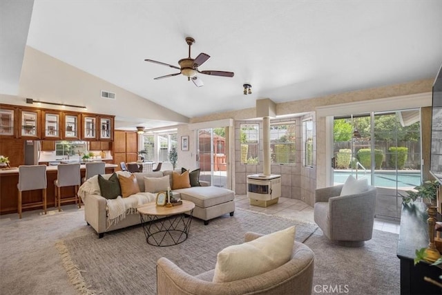 tiled living room featuring ceiling fan and vaulted ceiling