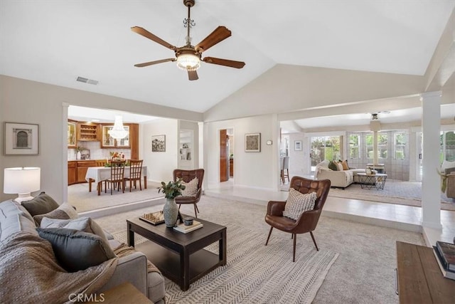 living room with lofted ceiling, ceiling fan, visible vents, baseboards, and decorative columns